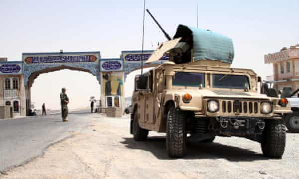 Afghan National Army (ANA) soldiers stand guard on a road side check point in Herat, 10 July 2021