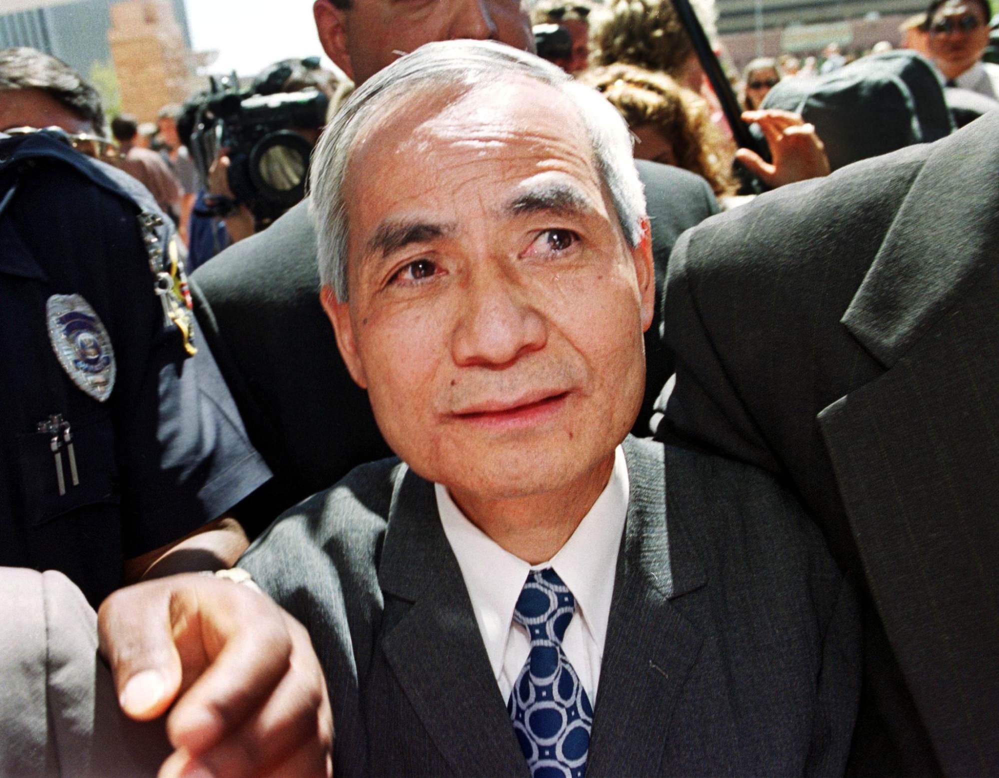 Former Los Alamos National Laboratory nuclear scientist Li Wenho is escorted back into the federal courthouse after addressing the media following his release from nine months of solitary confinement on September 13, 2000, in Albuquerque, New Mexico, USA. Photo: AFP