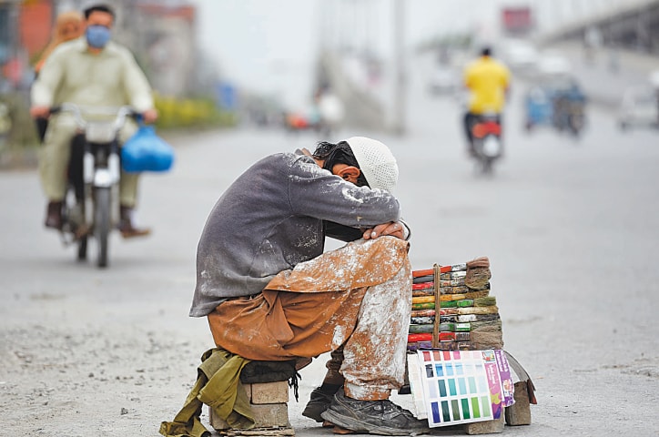 A painter sits idly by the side of a road in Rawalpindi, waiting for customers | Tanveer Shahzad/White Star