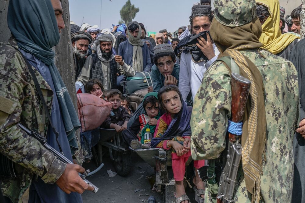 Taliban members stop people rushing to pass to Pakistan from the Afghanistan border on Sept. 25.