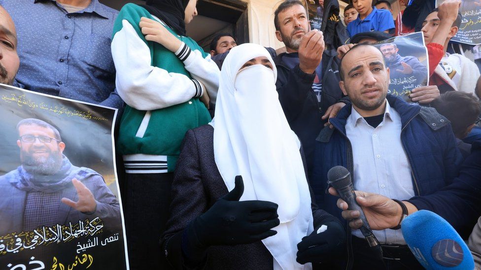 Randa Mousa (C), the wife of Palestinian Islamic Jihad member Khader Adnan, speaks to journalists following his death, outside her home in Arraba, in the occupied West Bank (2 May 2022)