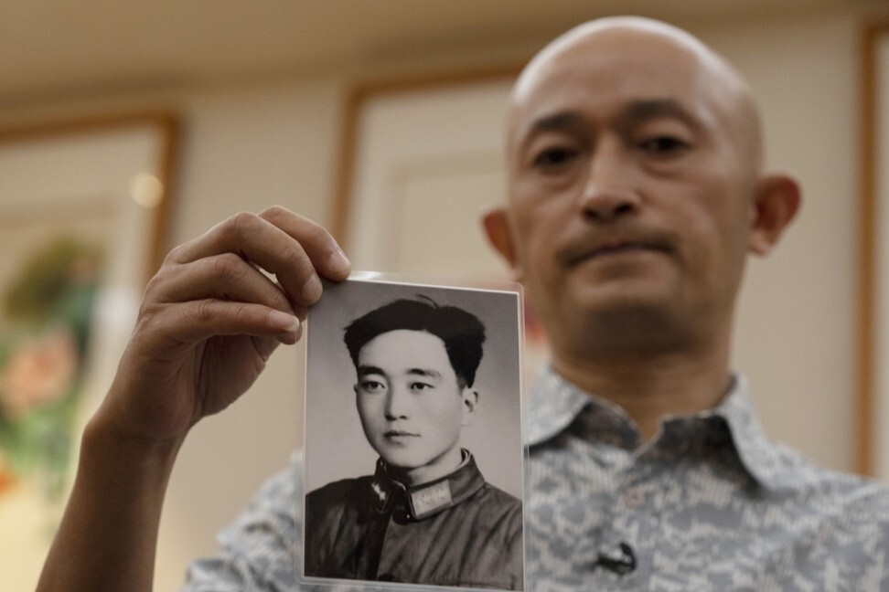 Zhang Hai holds up a photo of his father taken in his youth. Photo: AP