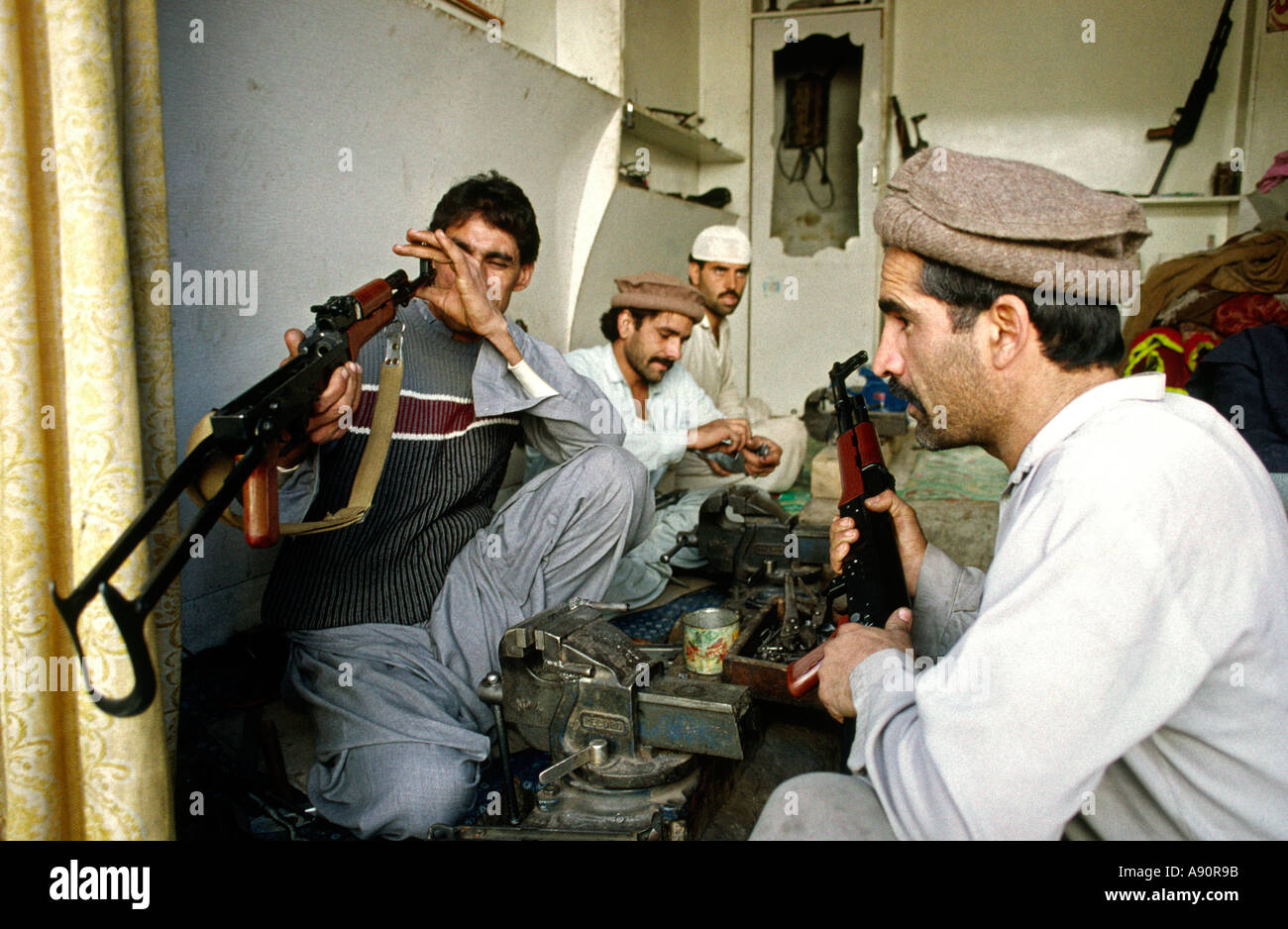 pakistan-nwfp-darra-adam-khel-maker-inspecting-ak47-kalashnikov-gun-A90R9B.jpg