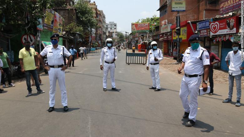 Indian police stand at a checkpoint after West Bengal announced a 15-day lockdown to curb the spread of coronavirus, in Kolkata on May 16, 2021.   