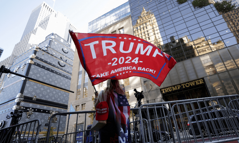  A person waves a Trump flag outside Trump Tower, after Donald Trump won the presidential election, in New York City on November 6. — Reuters 