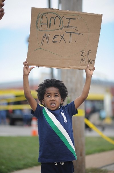A child participates in a peaceful protest on West Florissant Ave. in Ferguson, Missouri on August 19, 2014. (AFP)