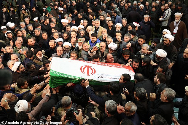 23045288-7860289-Iranians_carry_the_coffin_during_the_funeral_ceremony_of_Qasem_S-a-14_1578393630337.jpg