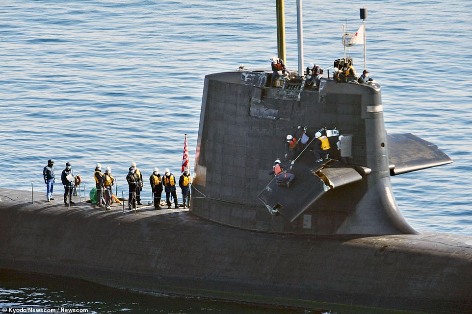 Pictured: A photo taken from a helicopter shows workers inspecting the Japanese Maritime Self-Defense Force submarine Souryu after the crash on Monday, off Kochi port in the western Japan main island of Shikoku on Feb. 9, 2021