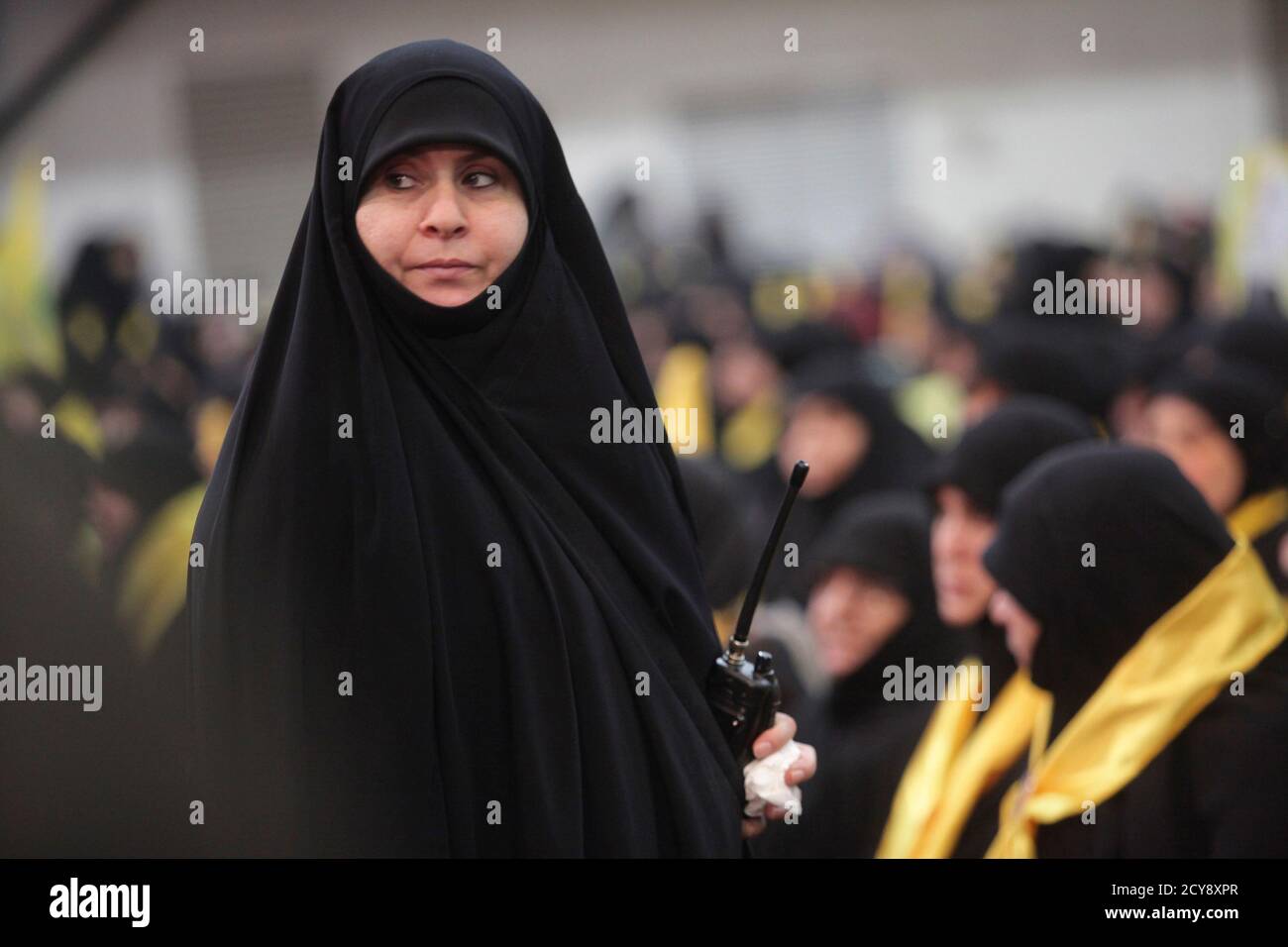 a-woman-carries-a-walkie-talkie-as-lebanons-hezbollah-leader-sayyed-hassan-nasrallah-appears-on-a-screen-to-speak-at-an-event-to-commemorate-the-deaths-of-six-hezbollah-fighters-and-an-iranian-general-killed-by-an-israeli-air-strike-in-syria-on-january-18-in-beiruts-southern-suburbs-january-30-2015-nasrallah-said-on-friday-his-group-did-not-want-war-with-israel-but-was-ready-for-one-and-had-the-right-to-respond-to-israeli-aggression-in-any-time-and-place-reuterskhalil-hassan-lebanon-tags-politics-civil-unrest-conflict-2CY8XPR.jpg