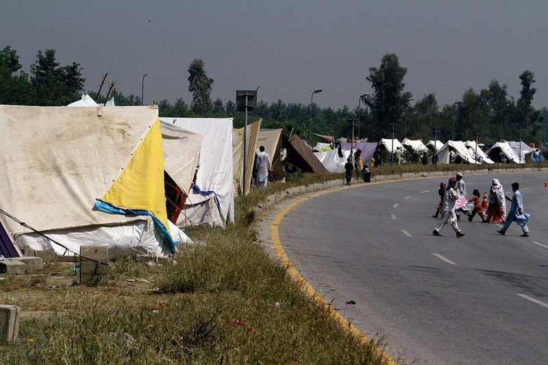 Displaced families take refuge on a roadside after fleeing their flood-hit homes, in Charsadda, Pakistan.