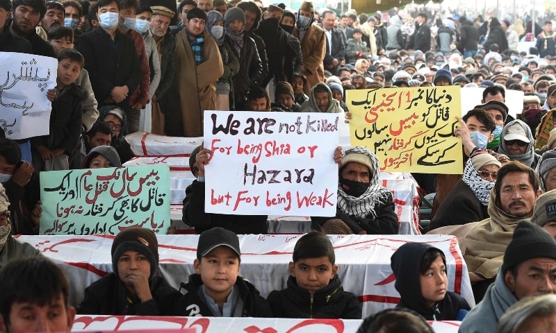 Mourners from the Shia Hazara community gather near coffins of the slain miners during a sit-in protest at the eastern bypass on the outskirts of Quetta on January 5. — AFP