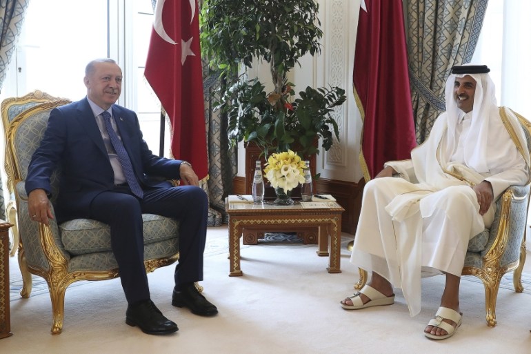 President Erdogan and Sheikh Tamim pose for photos for the media before their meeting in Doha [Presidential Press Service via AP]