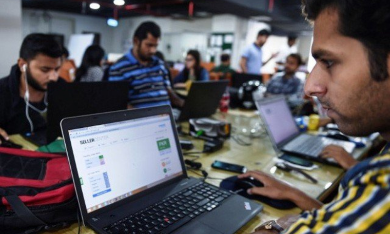 Pakistani employees of online marketplace company Kaymu work at their office in Karachi. — AFP/File