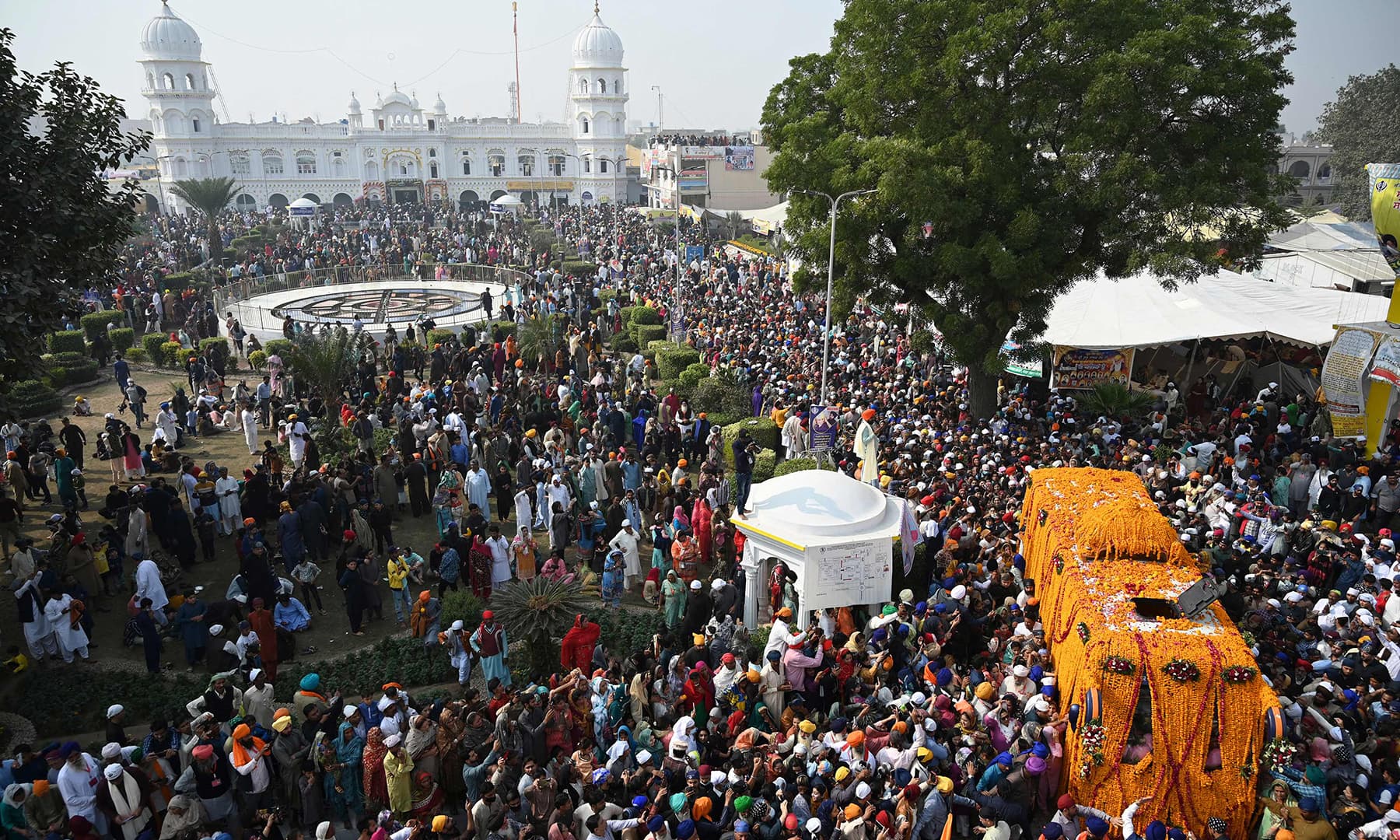 Sikh pilgrims gather around a bus carrying the Guru Granth Sahib (Sikh holy book) during a religious procession in Nankana Sahib. — AFP