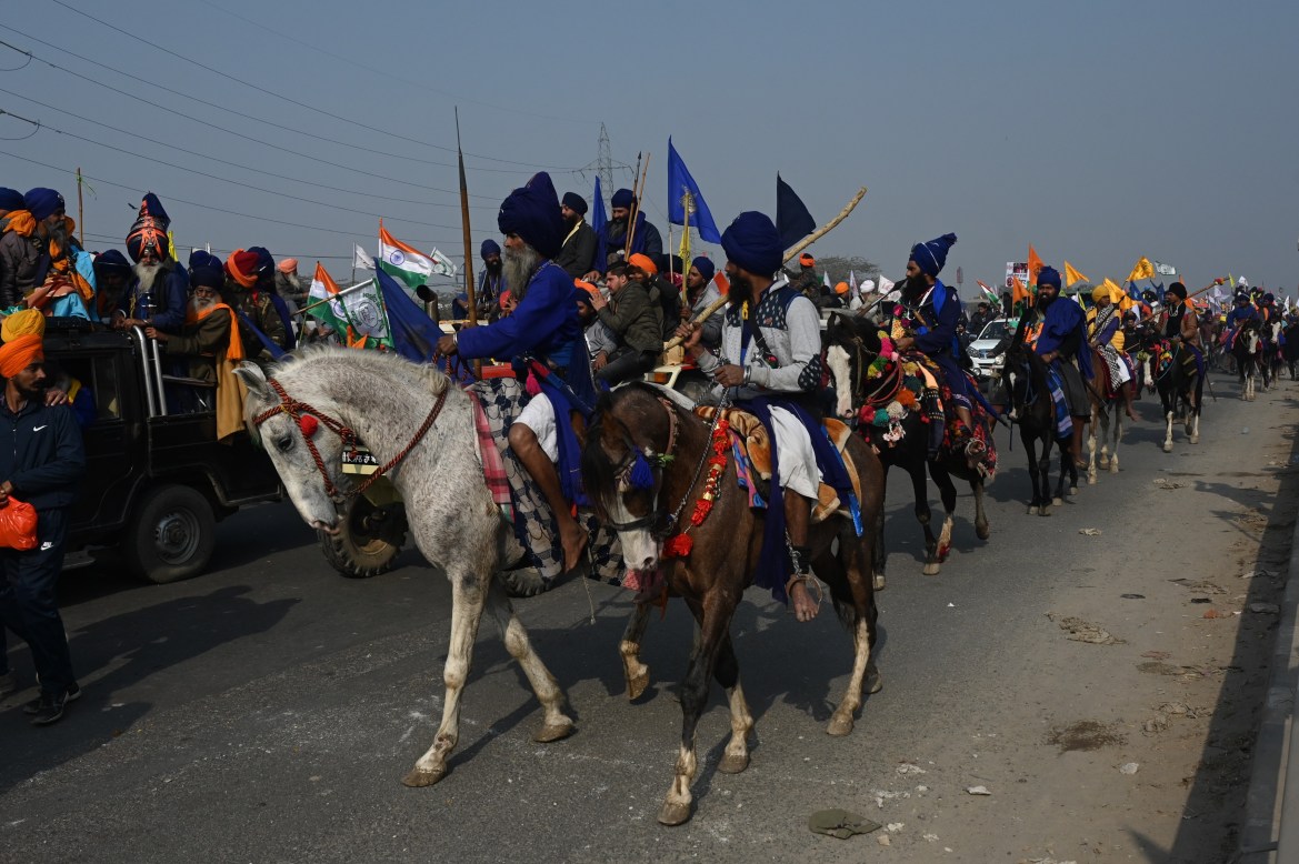 Nihangs or Sikh warriors on their horses take part in a rally to support protesting farmers in New Delhi. [Money Sharma/AFP]