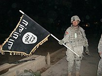210px-U.S._Army_soldier_with_captured_ISIS_flag_in_Iraq%2C_December_2010.jpg