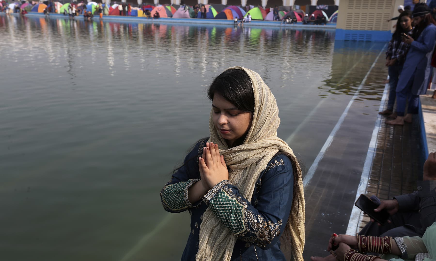 A Sikh woman performs rituals during a ceremony to celebrate the birth anniversary of Baba Guru Nanak Dev, at Nankana Sahib on Friday. — AP