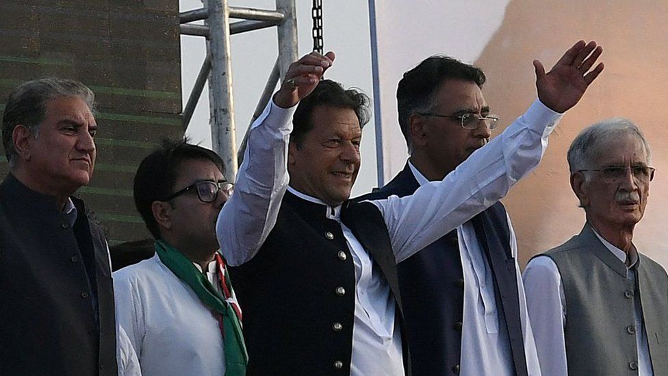 Pakistan's Prime Minister Imran Khan (C) along with other lawmakers, gestures upon his arrival to address the supporters of ruling Pakistan Tehreek-e-Insaf (PTI) party during a rally in Islamabad on March 27, 2022.
