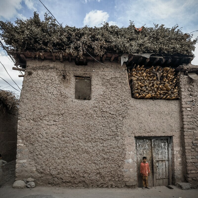 A young boy stands outside a house in Parachinar.