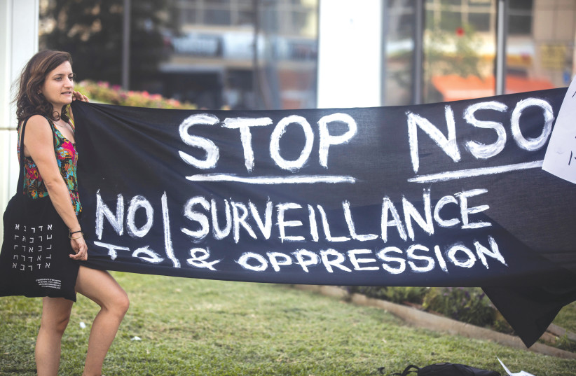  A PROTESTER HOLDS a banner during a protest attended by about a dozen people outside the offices of the Israeli cyber firm NSO Group in Herzliya, last week.  (credit: NIR ELIAS / REUTERS)