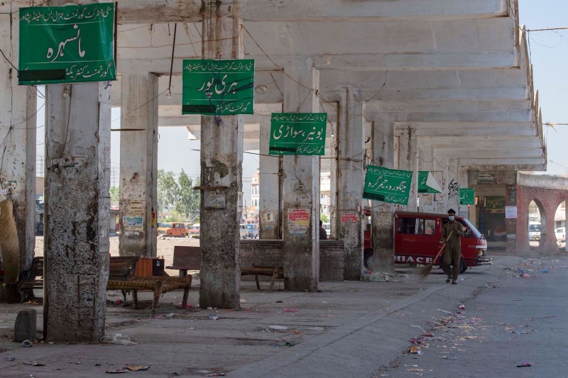 A sweeper cleans a deserted bus station after the provincial government suspended public transport during a lockdown in Peshawar, Pakistan, on April 3.