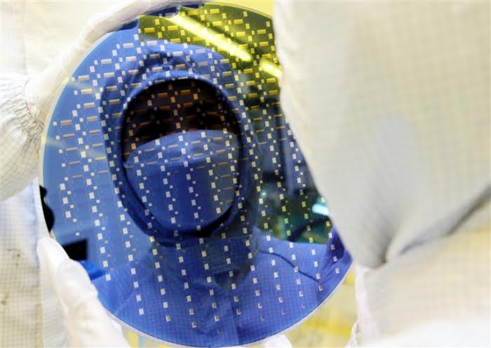 A Samsung employee examines a chip wafer