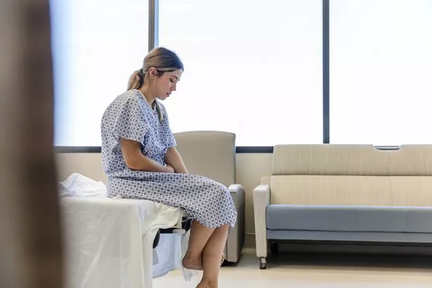 0_Anxious-sad-young-woman-wearing-hospital-gown-looks-down.jpg