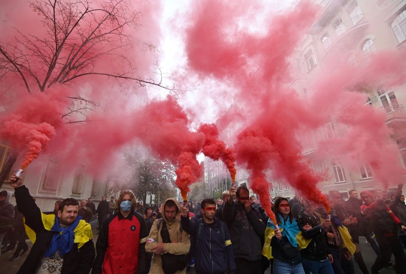 Demonstrators hold smoke grenades as they gather in Kyiv, Ukraine.