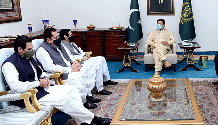 Speaker Punjab Assembly Chaudhry Pervaiz Elahi (third left), PML-Q leader Tariq Bashir Cheema (second left), and Federal Minister for Water Resources Chaudhry Moonis Elahi (first left) meet Prime Minister Imran Khan in Islamabad, on July 7, 2021. — APP