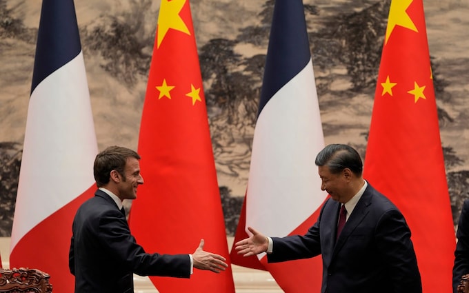 French President Emmanuel Macron shakes hands with Chinese President Xi Jinping