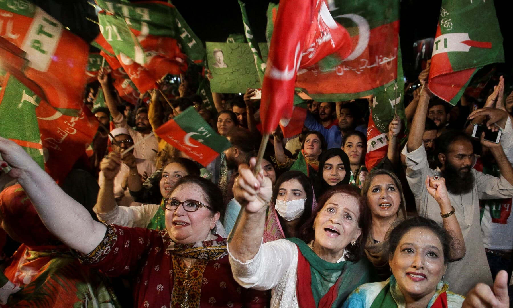 PTI supporters wave flags and chant in support of former prime minister Imran Khan during a rally in Lahore on April 10. — Reuters