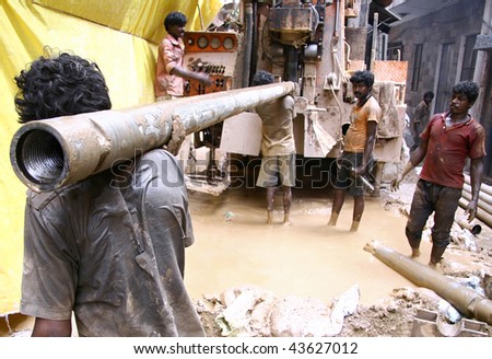 stock-photo-dehli-sept-hard-working-indians-boring-a-hole-to-access-water-on-september-in-dehli-43627012.jpg
