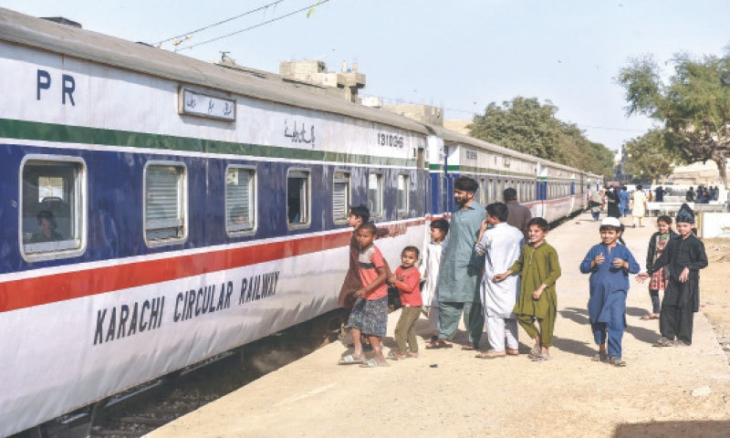 CURIOUS onlookers examine the newly launched KCR train on Wednesday and (right) bemused motorists watch the train pass at a level crossing.—Fahim Siddiqi / White Star