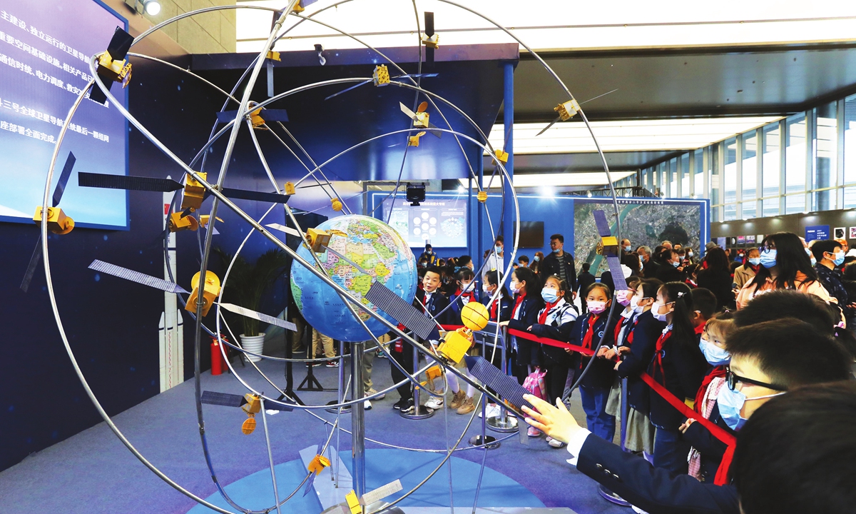 Young students take a close look at a model of the BeiDou global navigation network on Tuesday in Nanjing, capital of East China's Jiangsu Province. The space science popularization exhibition was officially opened to the public Tuesday. Photo: VCG