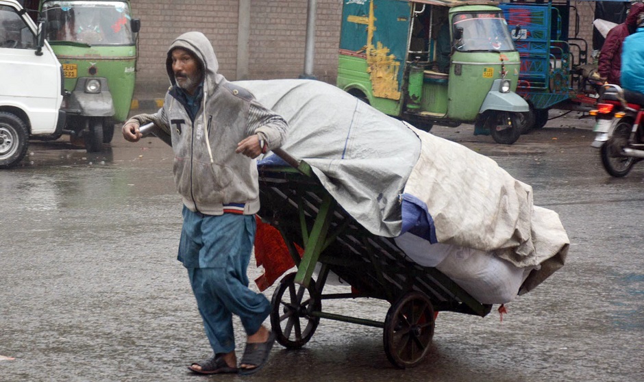 a-labor-carries-a-loaded-wheelbarrow-during-a-rain-spell-in-lahore-.online-1578382038.jpg