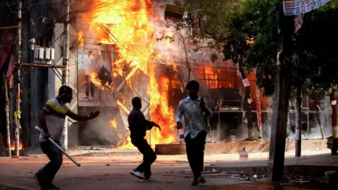 Getty Images  A garment store is reportedly set ablaze in Dhaka on August 4, 2024