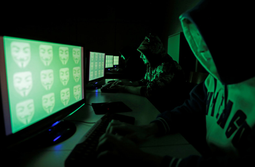  People pose in front of a display showing the word 'cyber' in binary code, in this picture illustration taken in Zenica December 27, 2014. Picture taken December 27, 2014. (photo credit: REUTERS/DADO RUVIC/FILE PHOTO)