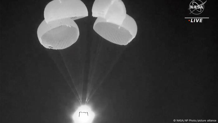 SpaceX Dragon capsule uses parachutes as it descends in the Gulf of Mexico 