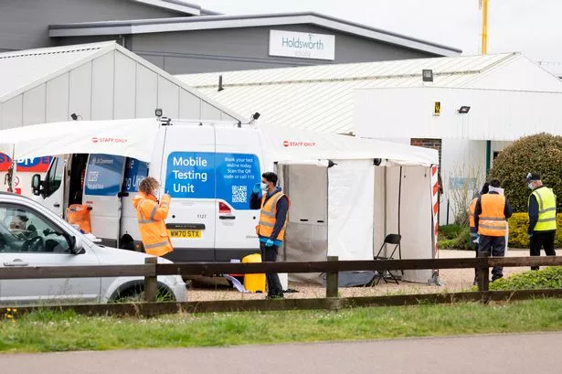 Staff stand at a mobile Covid testing unit as surge testing is carried out at Seasons Garden Centre, Bedford Road, Wixams