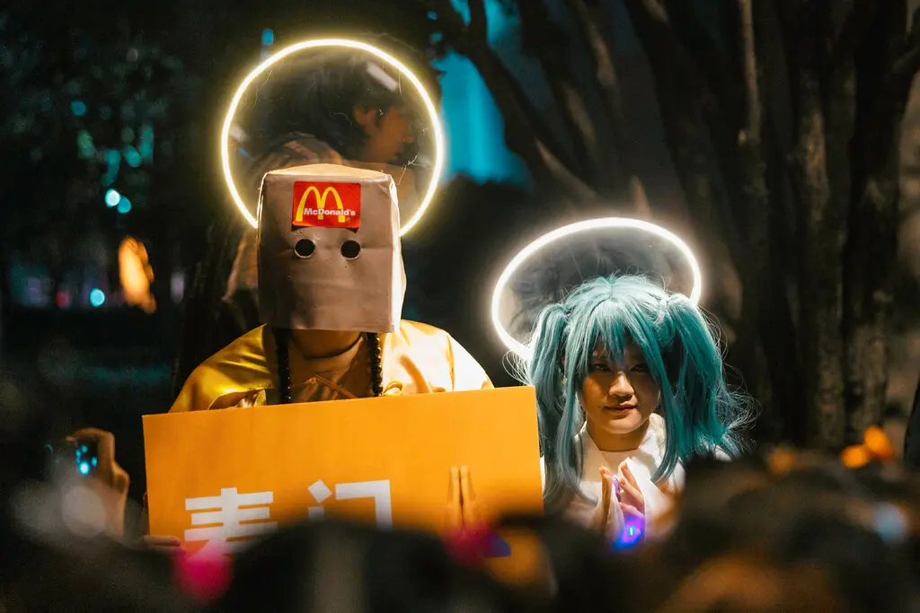 Two people dressed as followers of a fake MacDonalds religion in reference to a internet meme at Shanghai's Halloween parade.