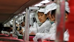 FILE - Workers at a Foxconn factory in Longhua, Guangdong province, China, May 26, 2010. Foxconn is Apple's main supplier of iPhones.