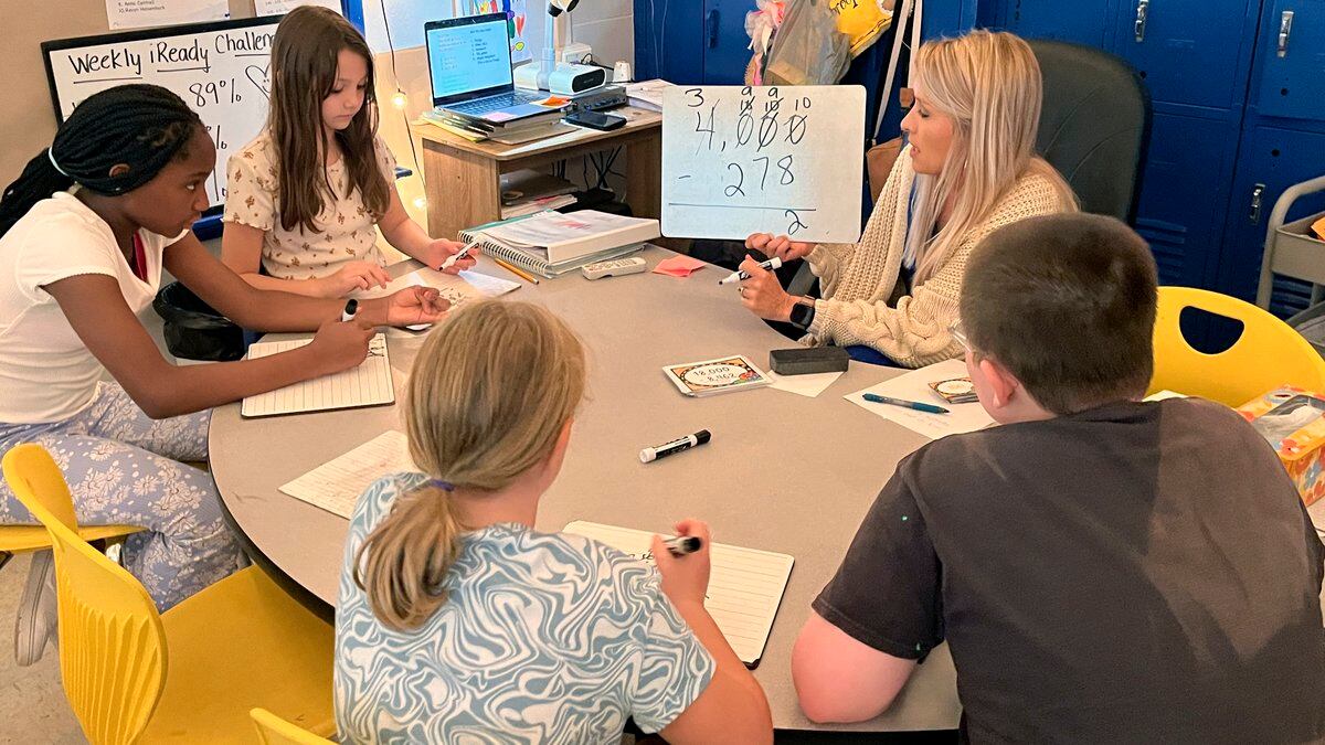 Piedmont Elementary School math teacher Cassie Holbrooks helps a small group of fourth-grade...