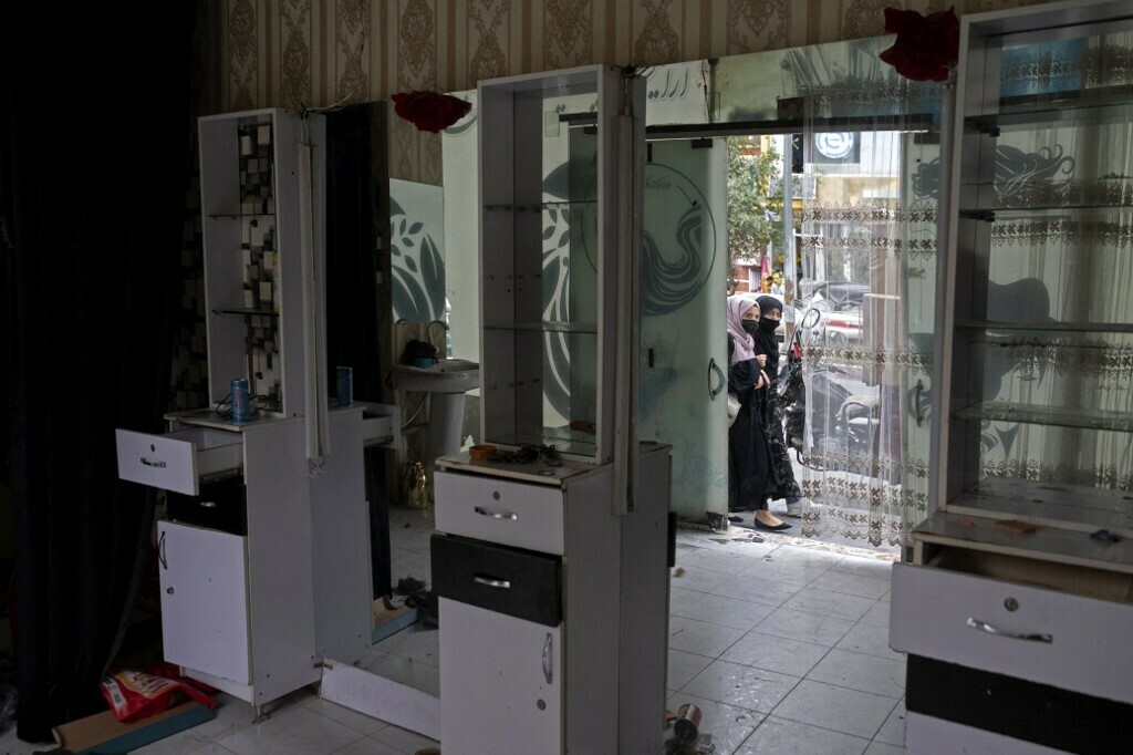 Afghan women peek through the door of a vacated beauty parlour in Kabul on July 25, 2023. Afghanistan’s Taliban authorities have ordered beauty parlours across the country to shut within a month, the vice ministry confirmed the latest curb to squeeze women out of public life. Photo: AFP 