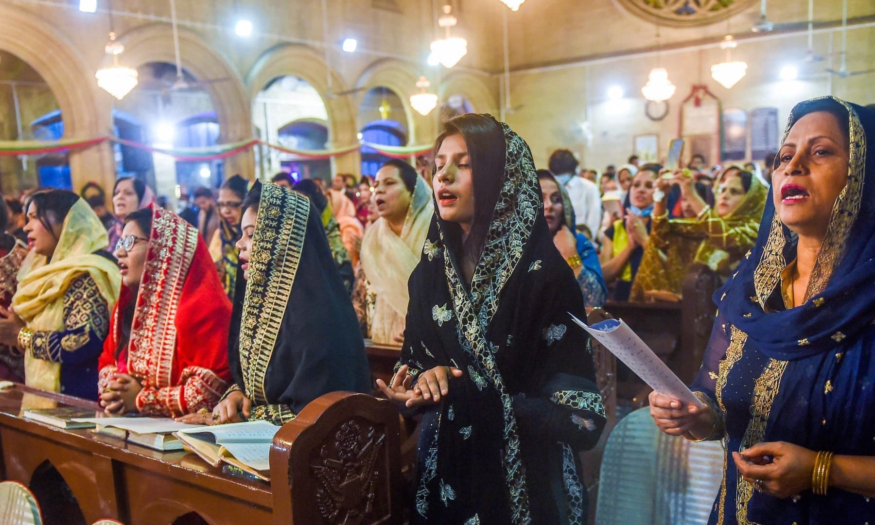 Christian devotees pray at Saint Andrew Church to celebrate Christmas in Karachi on December 24, 2021. — AFP