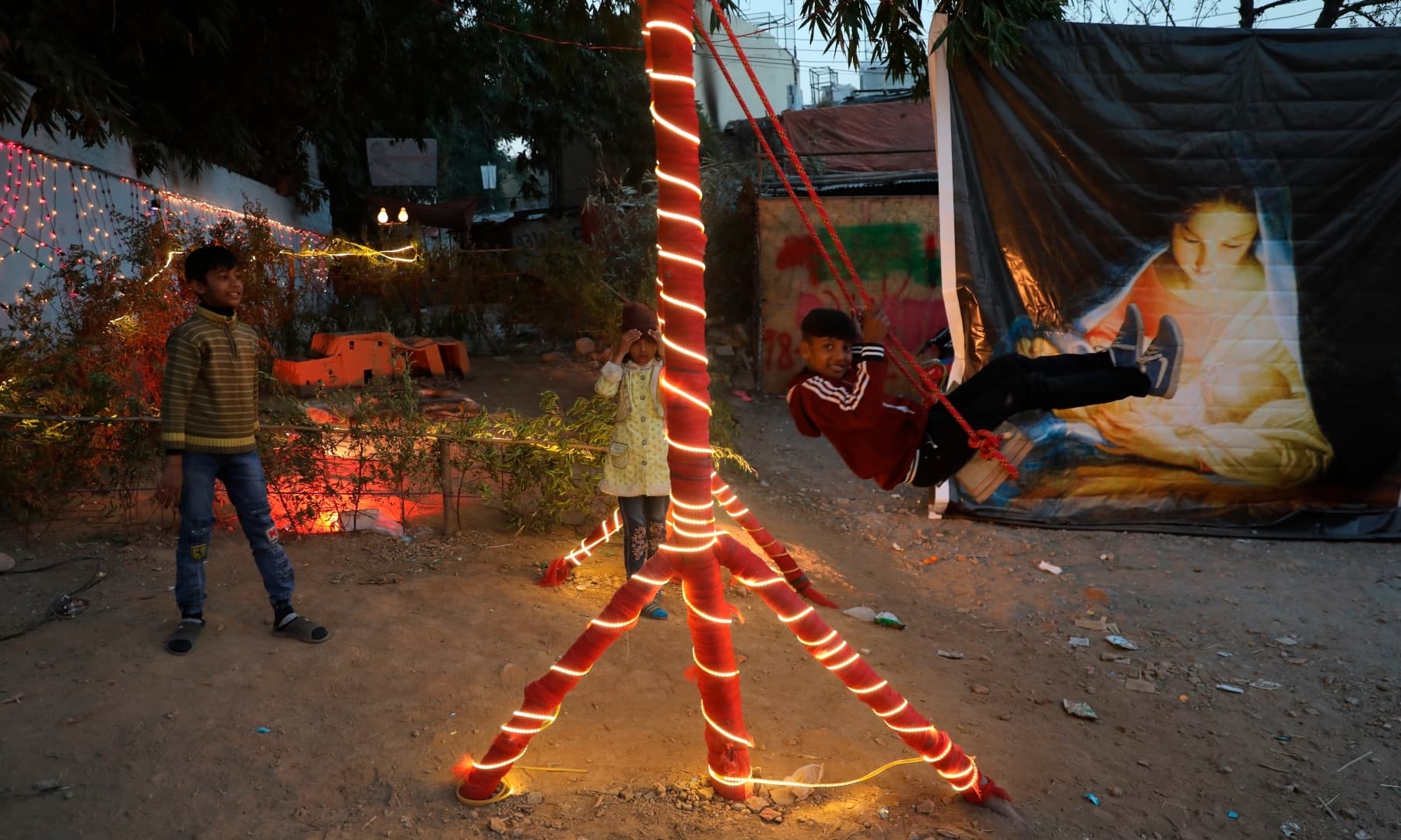 A boy plays on a swing during Christmas celebrations at a neighbourhood in Islamabad on December 25, 2021. — AP