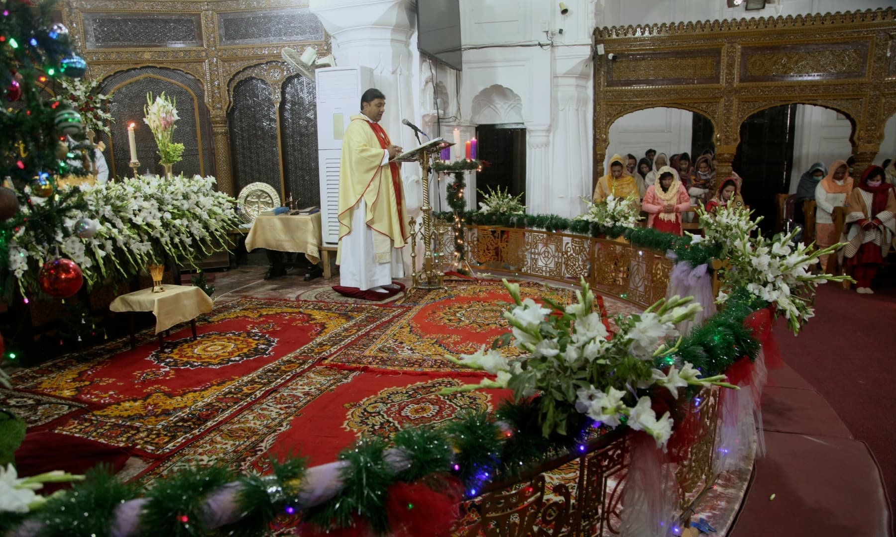 Devotees attend a Christmas mass at All Saints' Anglican Church in Peshawar on December 25, 2021. — AP