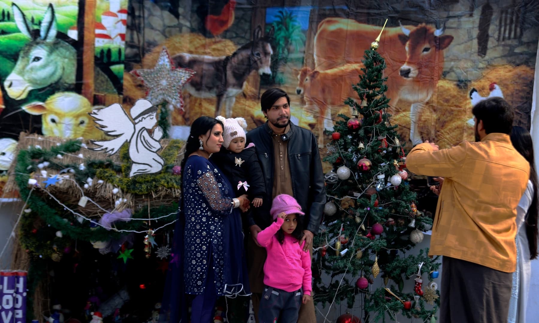 A family poses for a photograph after attending a Christmas mass at All Saints' Anglican Church in Peshawar on December 25, 2021. — AP