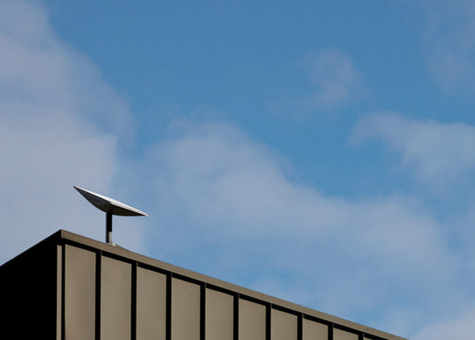 A Starlink receiver on top of a building.