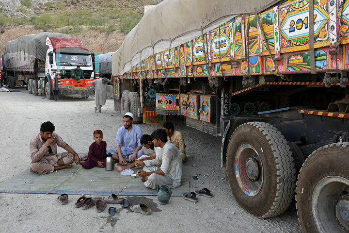 drivers along with a boy drink tea next to trucks parked along a road near the pakistan afghanistan border in torkham photo afp