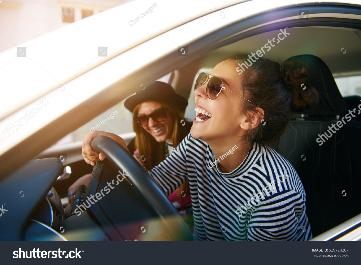 stock-photo-laughing-young-woman-wearing-sunglasses-driving-a-car-with-her-girl-friend-close-up-profile-view-529724287.jpg